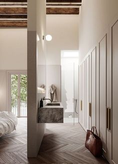 a bedroom with white walls and wood flooring next to a bed in a room