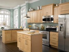 a large kitchen with wooden cabinets and stainless steel appliances