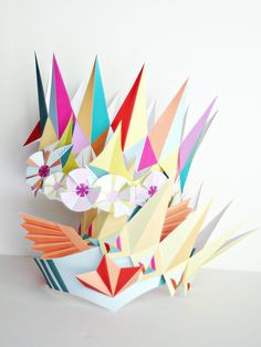 an origami bird sculpture made out of folded paper on a white table top