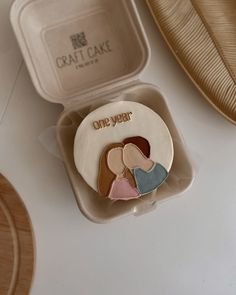 an open box with two different colored heart shaped buttons in it on a white surface