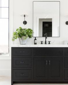 a bathroom with two sinks and a large mirror on the wall next to a window