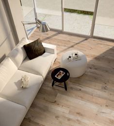 a modern living room with white furniture and wood flooring