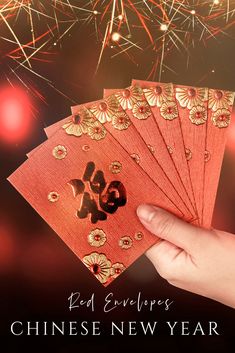 red envelopes with the chinese new year written on them and fireworks in the background