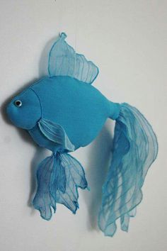 a blue fish hanging from the side of a wall