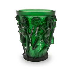 a green glass vase sitting on top of a table