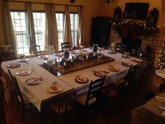 a dining room table is set with plates and place settings for christmas dinner party guests