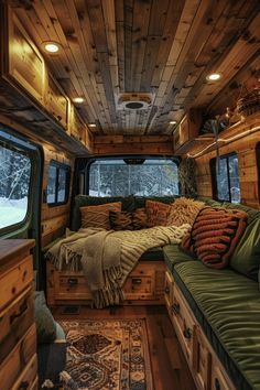 the interior of an rv with wood paneling on the walls and ceiling, including a bed