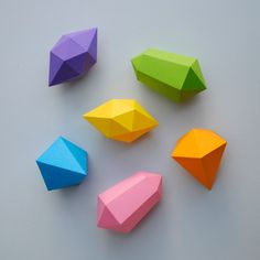 five different colored origami shapes on a gray surface