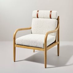 a wooden chair with a white upholstered seat and back cushion, on a gray background