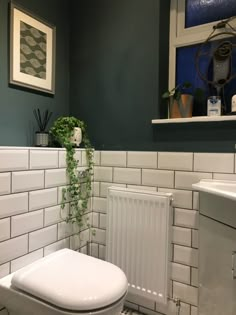 a white toilet sitting in a bathroom next to a radiator and wall mounted air conditioner