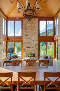 a dining room table and chairs in front of large windows with wood trimmings