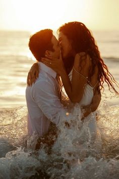 two people in the water kissing each other