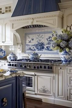 a blue and white kitchen with an oven, stove top and counter tops in it