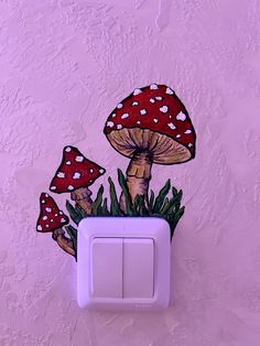 a light switch cover with mushrooms painted on it