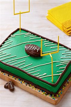 a football field cake on a table with chocolate candies and sprinkles