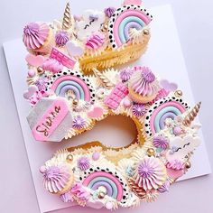 the letter e made out of cupcakes is decorated with unicorns and rainbows