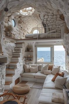 a living room filled with lots of furniture next to a window on top of a stone wall