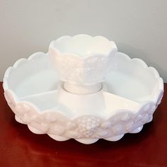 a white bowl sitting on top of a wooden table next to a red tablecloth