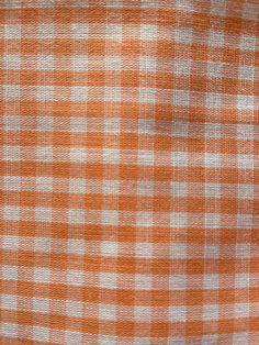 an orange and white checkered fabric is shown in close - up view, with no pattern