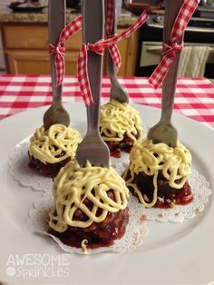 three small pastries with spaghetti on them are sitting on a plate next to utensils