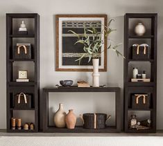 a shelf with vases, baskets and other items on it in a living room