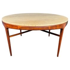 an oval table with marble top and wooden legs