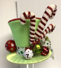 a green hat with red and white candy canes in it sitting on a table