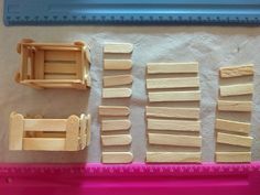 several pieces of wood sitting on top of a pink plastic tray next to a ruler