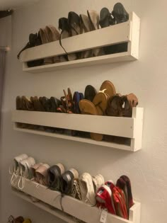 two white shelves filled with pairs of shoes