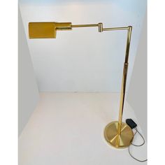 a lamp that is on top of a white table next to a light bulb and plugged in