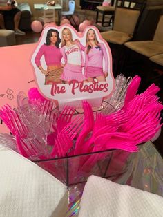 the plasticies are in a basket with pink flowers on it and there is a sign that says, the plasticies