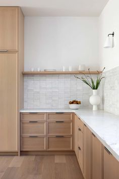 a kitchen with wooden cabinets and white marble counter tops, along with wood flooring