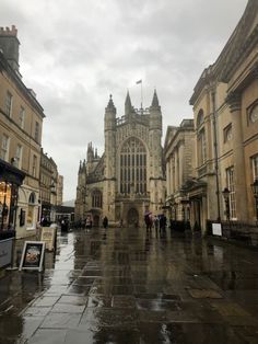 people are walking in the rain near some buildings