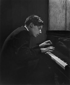 a man sitting at a piano with his hands on the keys