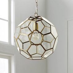 a light fixture hanging from the ceiling in a room with white walls and window frames