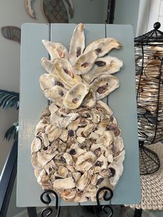 a pineapple made out of oysters sitting on top of a blue tablecloth