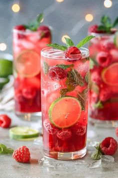 two glasses filled with raspberry lemonade and limeade garnished with mint