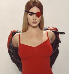 a woman in a red dress with a heart on her forehead and leather jacket over her shoulder