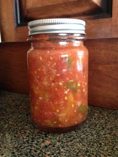 a jar filled with lots of food sitting on top of a counter next to a door