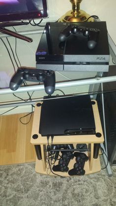 two video game controllers sitting on top of a table next to a monitor and keyboard