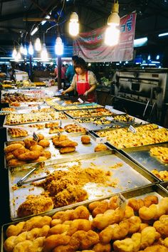 a woman standing in front of trays of food