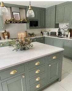 a kitchen with green cabinets and white counter tops