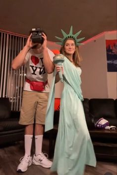 a man and woman dressed as the statue of liberty holding up cameras to take pictures