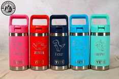 thermos are lined up in different colors and designs, with their lids open