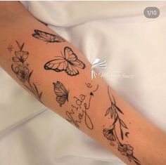 a woman's arm with butterflies and flowers on it