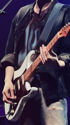 a man playing an electric guitar on stage