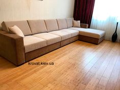 a couch sitting on top of a hard wood floor in a living room next to a window