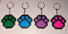 three key chains with different colored pixeles on them, one is black and the other is pink