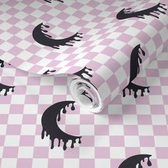 a pink and white checkered wallpaper with black splatters on the surface