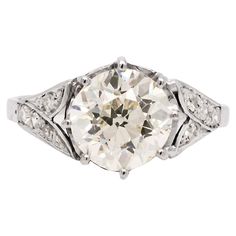 an antique style diamond ring with filigrees on the shoulders and sidestones